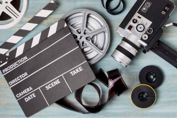 elevated view clapperboard film reels film strips camcorder blue wooden backdrop scaled 1